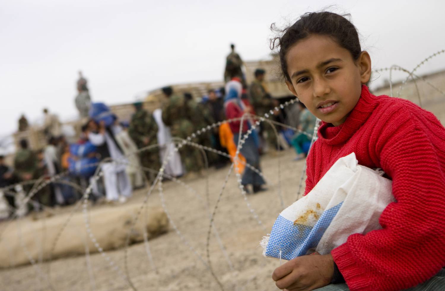 KANDAHAR, Afhanistan -- A young girl is watching over the distribution while she guards her own supplies until somebody comes to help her move it. Photo: Sgt Chris Halton RLC, British Army via Flickr